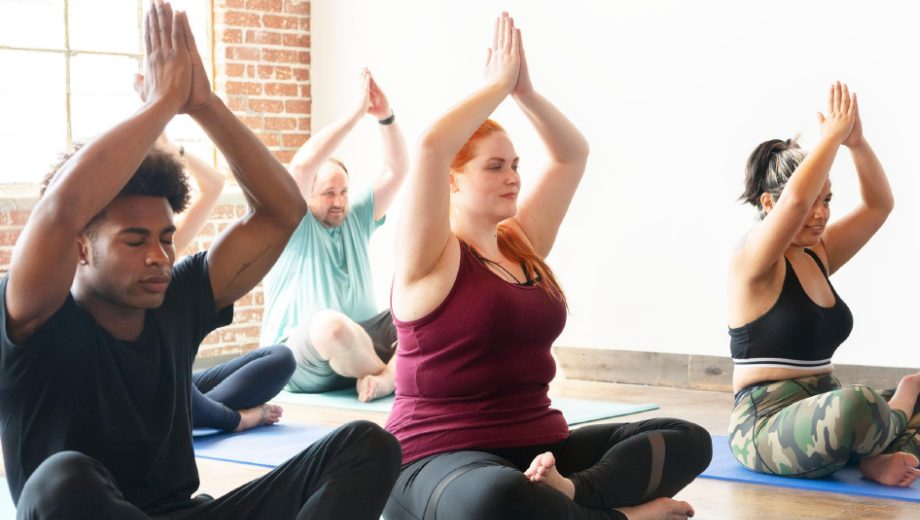 A diverse group practicing seated yoga together