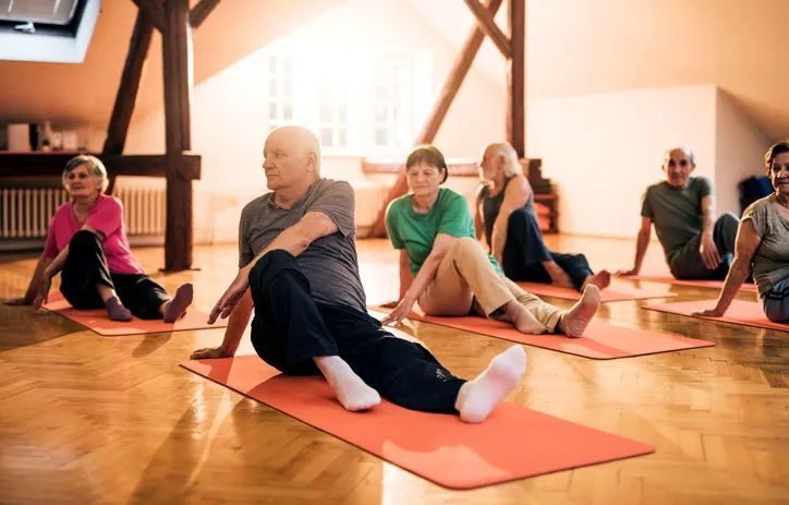 Older adults practicing yoga together on mats